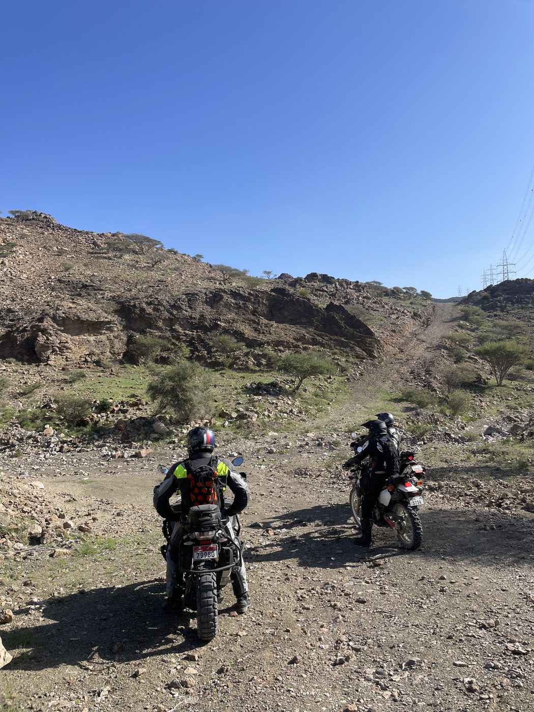 Riders climbing a rocky wadi